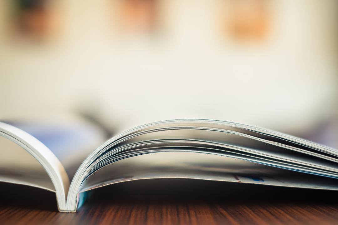 Offen liegendes Magazin auf einem Holztisch in Nahaufnahme.