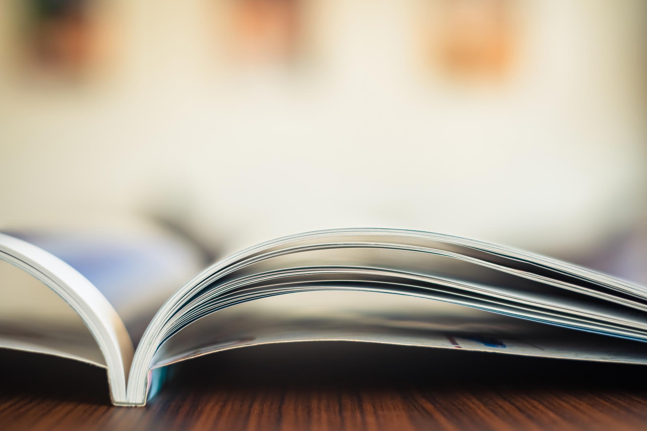 Offen liegendes Magazin auf einem Holztisch in Nahaufnahme.