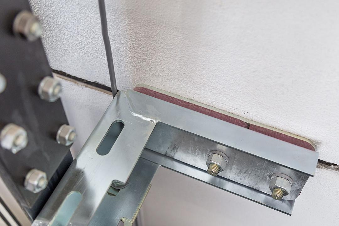 Nahaufnahme einer Aufzugsisolierung mit Aufzugsführungsschiene befestigt mit einer Ankerschiene an der Wand