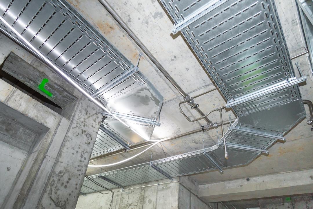 Betonrohbau mit an der Wand und Decke montierten Kabeltrassen, Lichtschlauch für die Beleuchtung