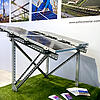 A sample of a solar mounting system with solar panels mounted on it with a photo-printed wall in the background.