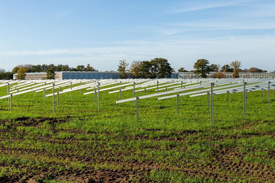 Unterkonstruktionen für Solarpanele auf einer grünen Wiese mit blauem Himmel