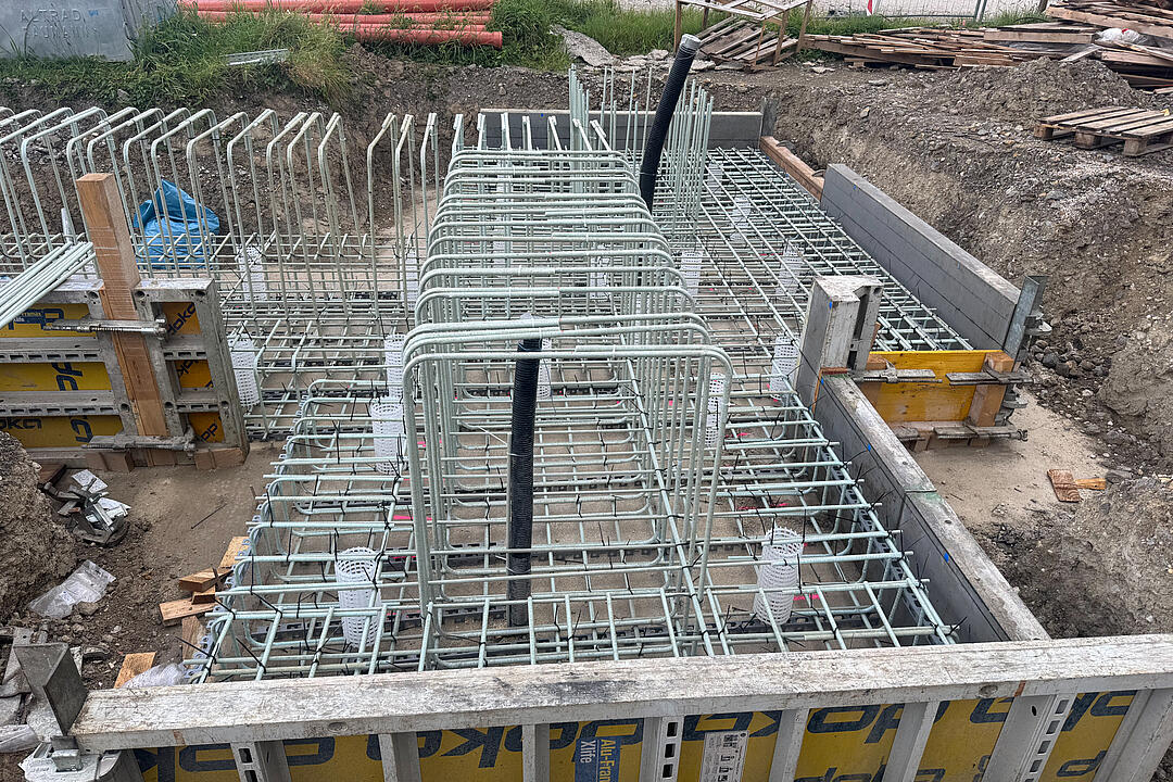 Gebogene GFK-Bewehrung auf einer Baustelle mit Holz-Metall-Verkleidung.