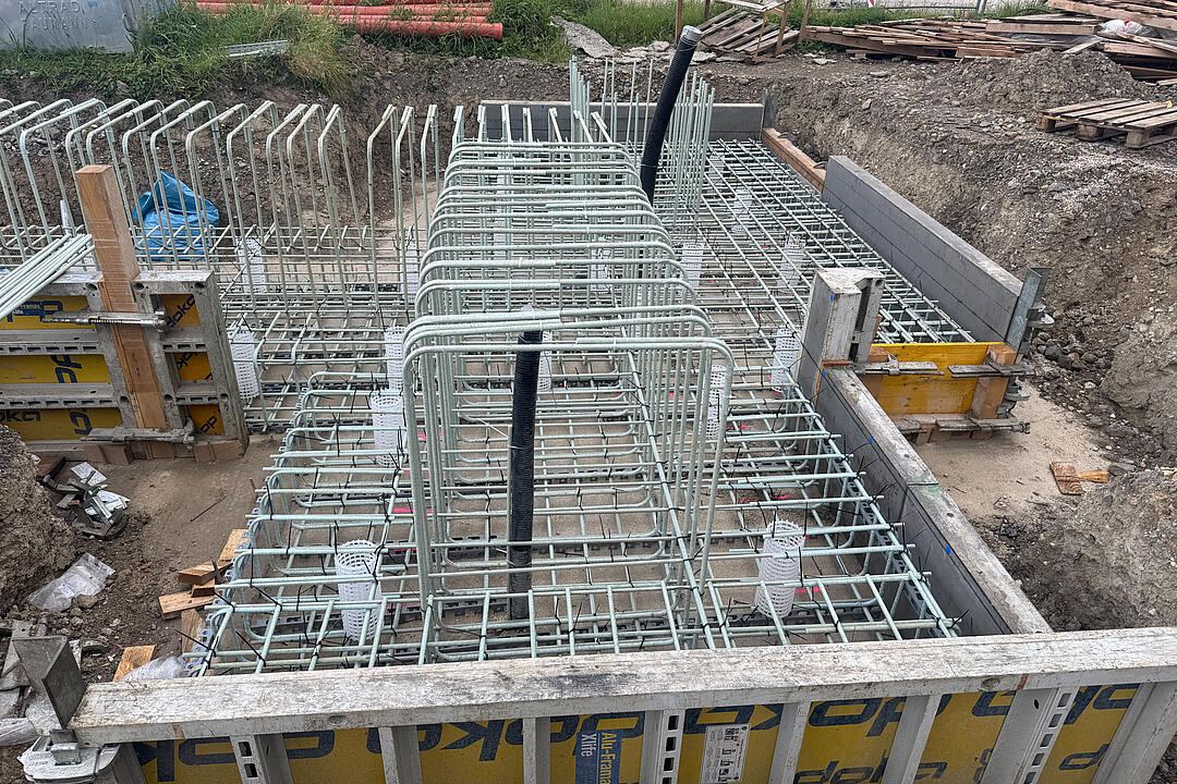 Gebogene GFK-Bewehrung auf einer Baustelle mit Holz-Metall-Verkleidung.