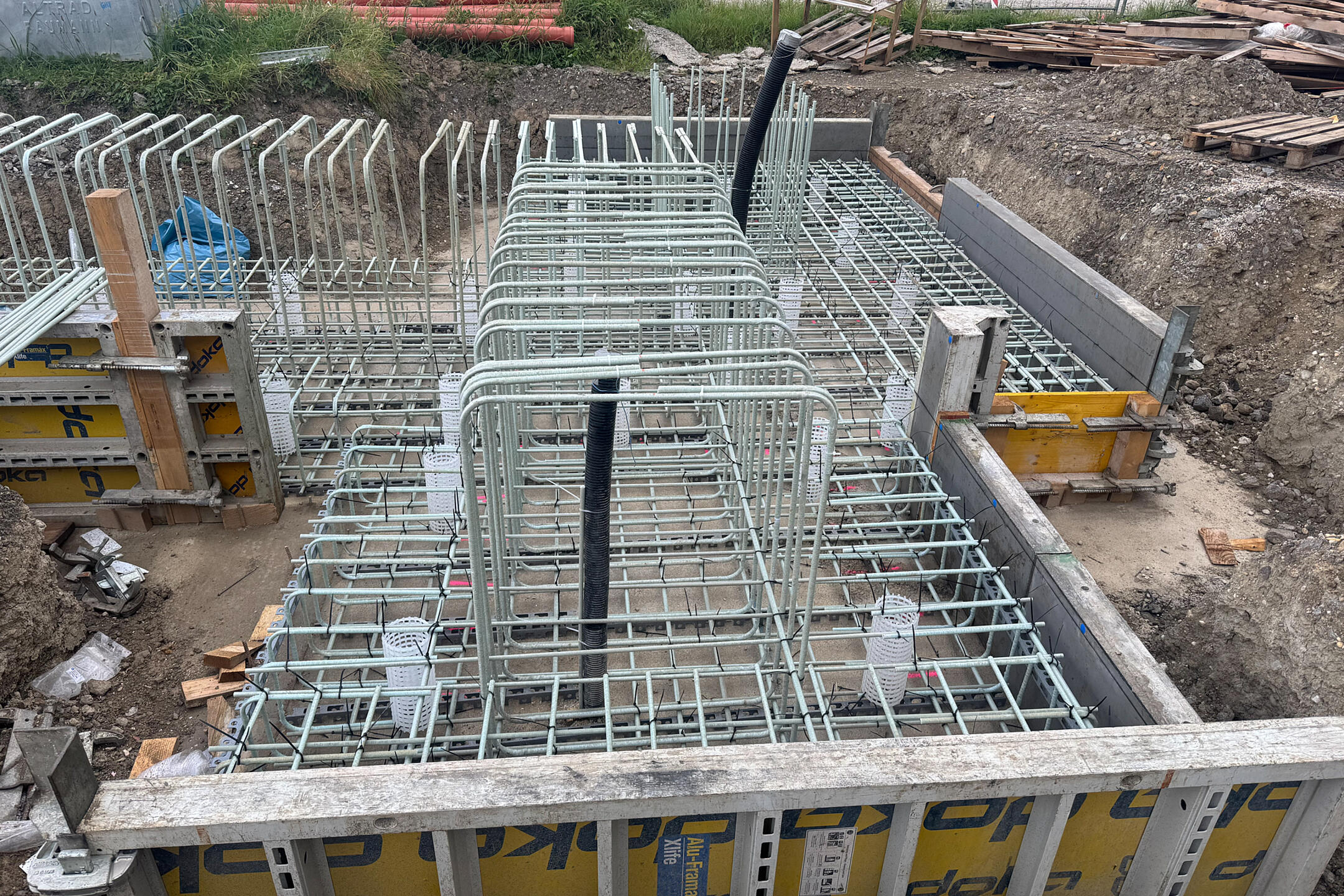 Gebogene GFK-Bewehrung auf einer Baustelle mit Holz-Metall-Verkleidung.