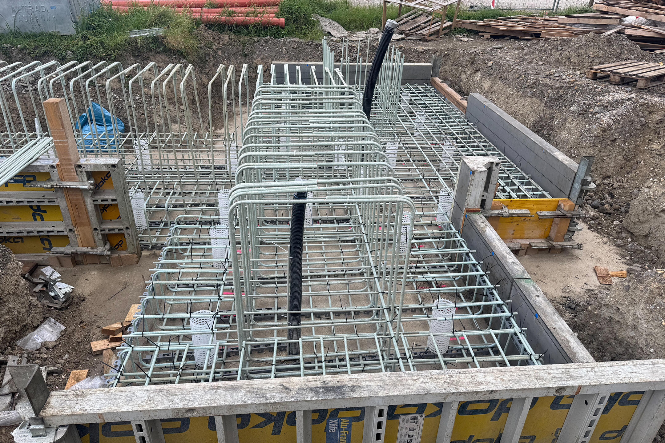 Gebogene GFK-Bewehrung auf einer Baustelle mit Holz-Metall-Verkleidung.