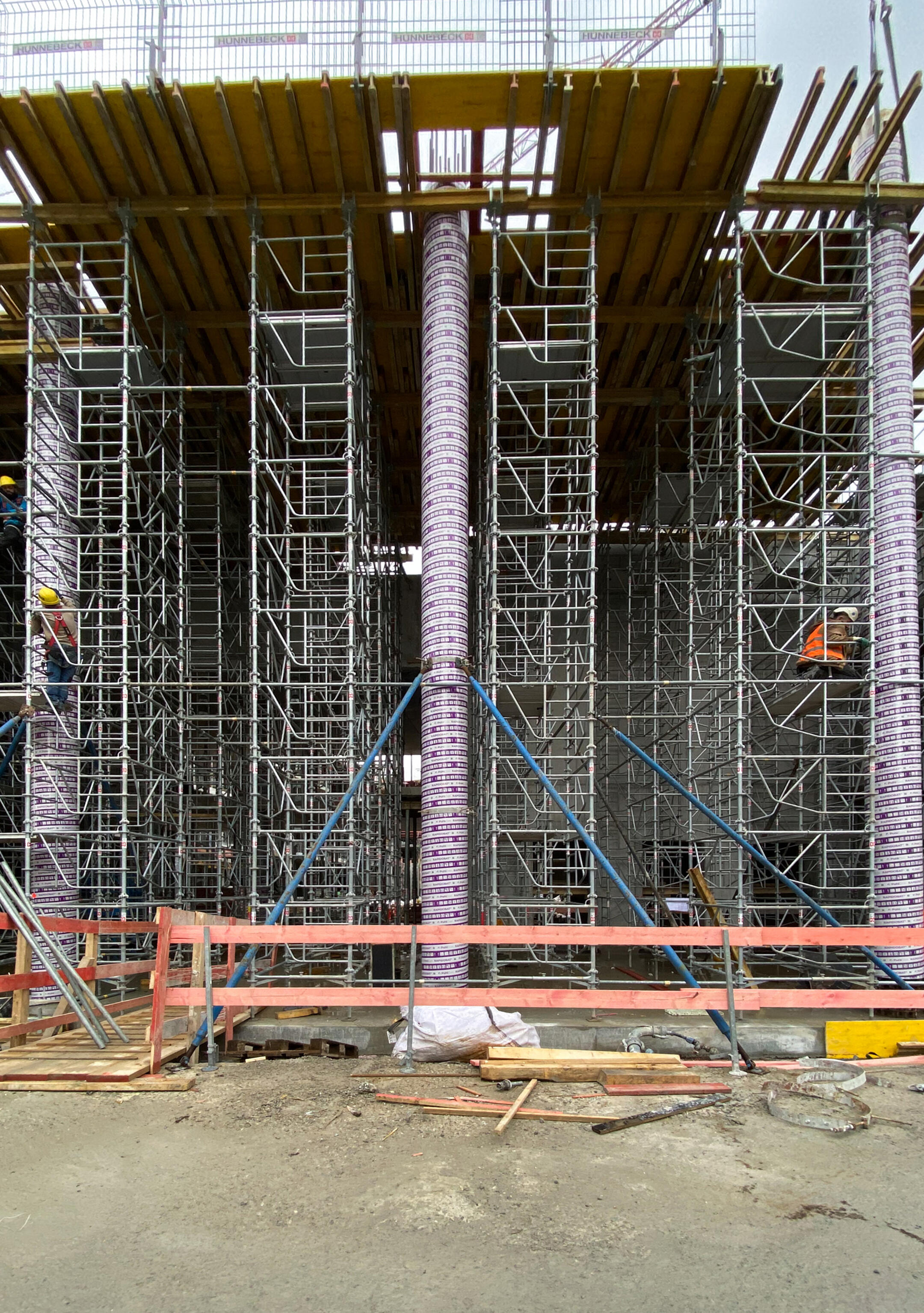 Eingeschalte Betonstütze auf einer Baustelle mit Baugerüsten umkleidet