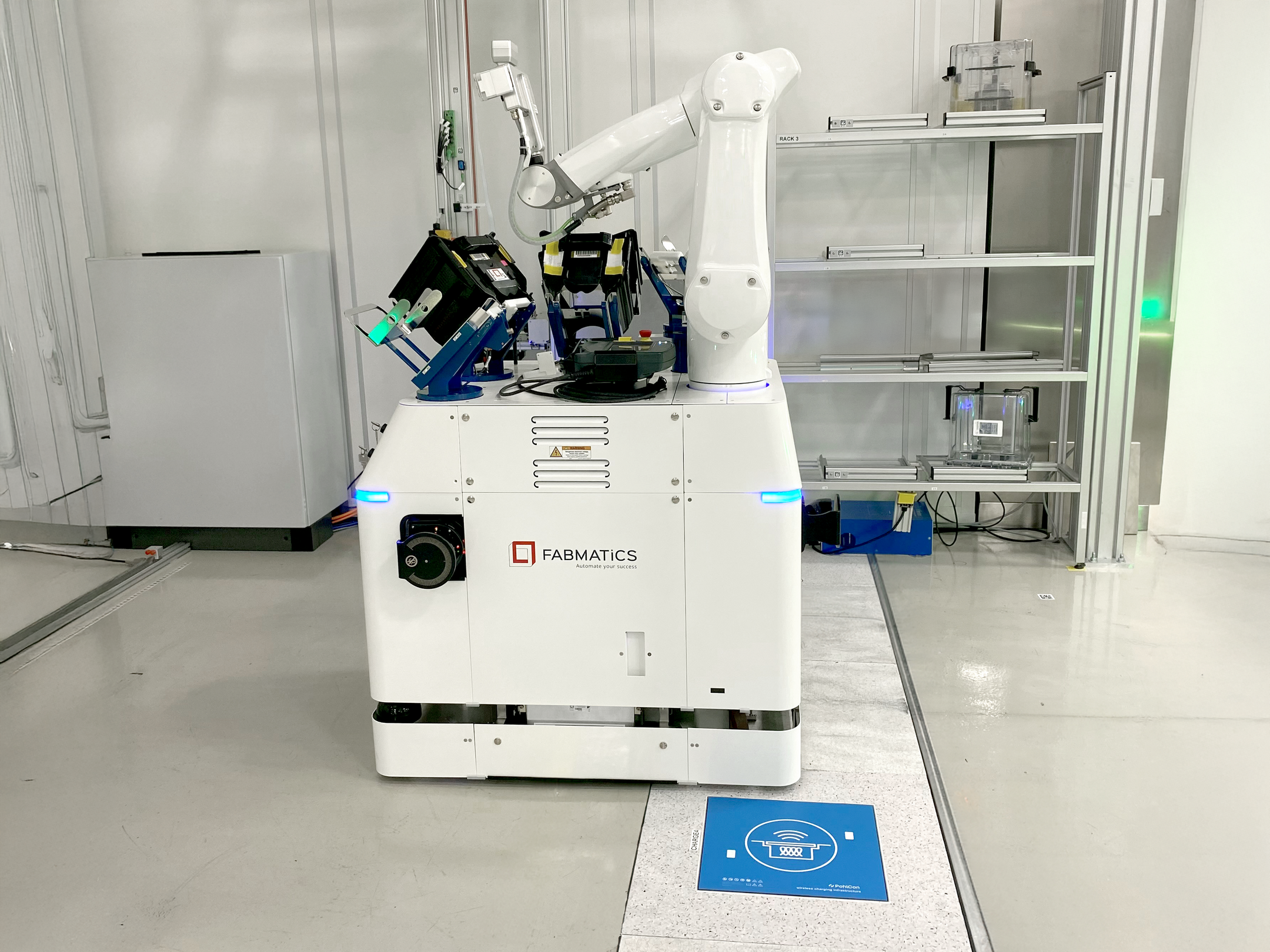 Ein Fabmatics-Roboter fährt in einem Labor über eine Wireless Charging Protection System (WCPS)-Ladestruktur.