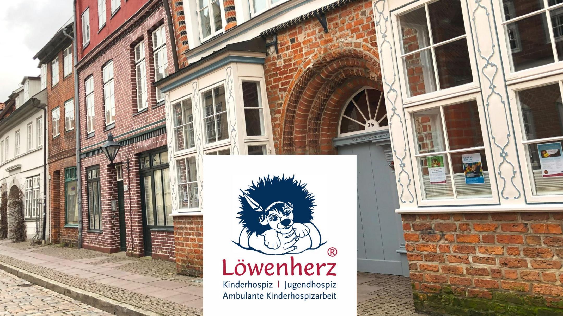 Häuser im Hintergrund, im Vordergrund ein Logo mit Löwe und Schriftzug "Löwenherz"