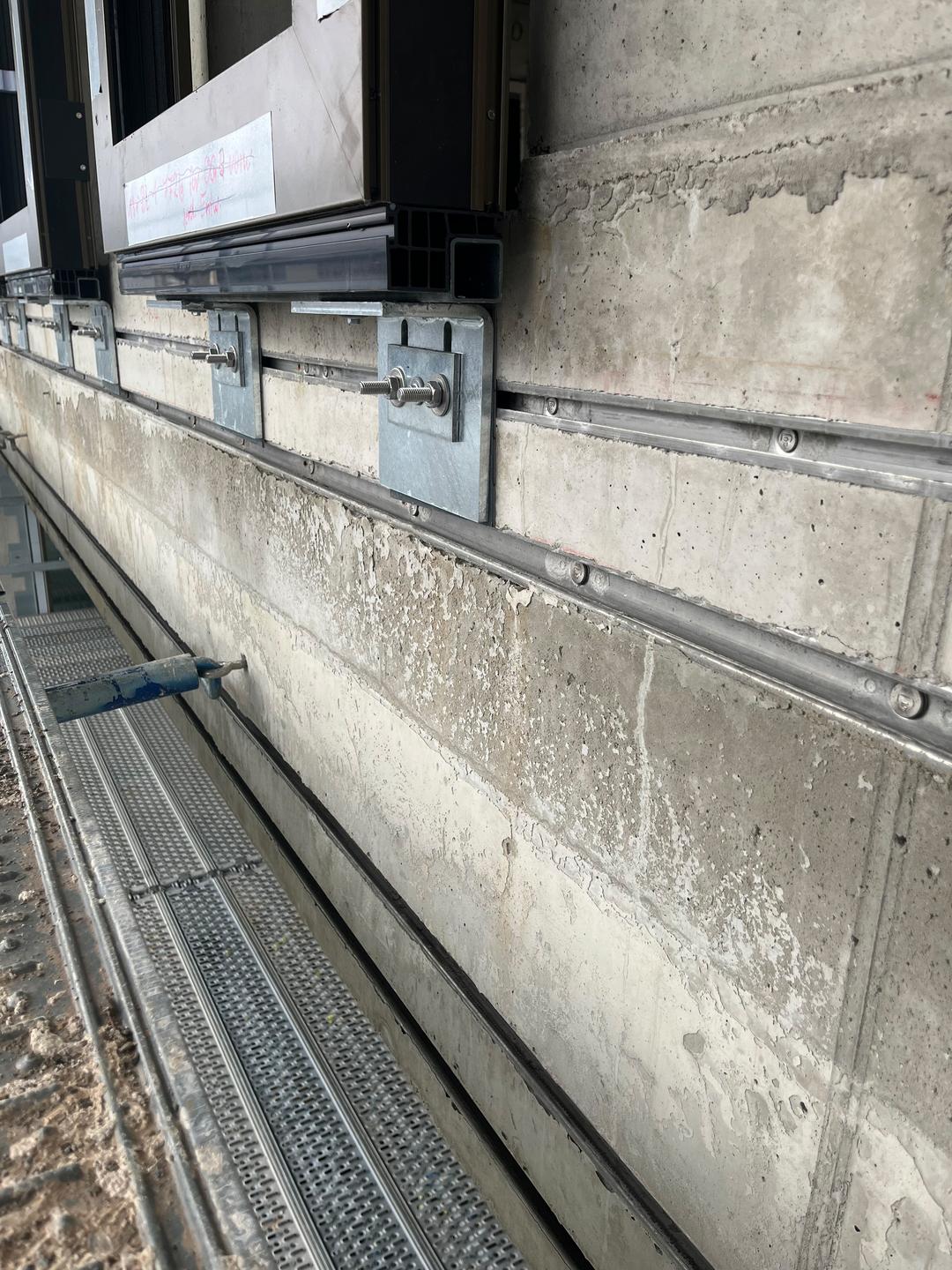 Betonwand mit eingelassenen Ankerschienen.