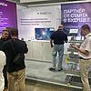 Messestand mit Infotafeln und Besuchern und Modell mit Kabeltragsystemen