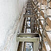 Blick zwischen Betonwand und Vorhangfassade mit Windposts