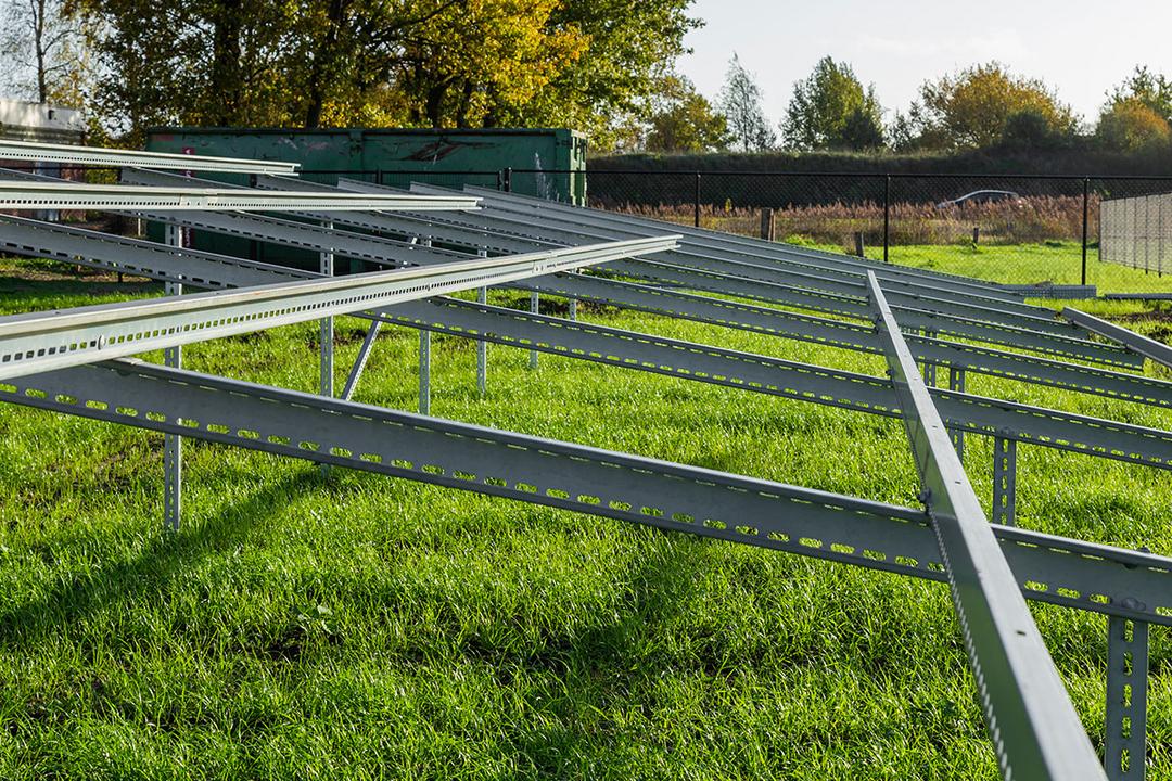 Rahmenstruktur aus Stützen, Quer- und Längsträgern auf grüner Wiese mit blauem Himmel