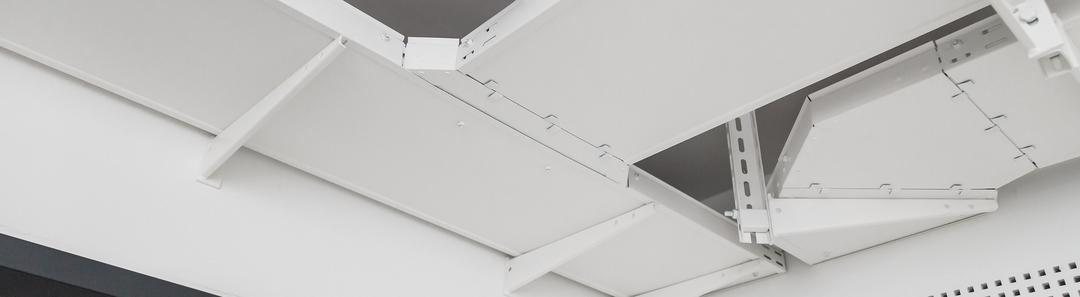 Weiß beschichtete Kabelrinnen von PohlCon an der Decke eines Büroraums.