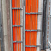 Orange Kabel werden durch metallene Leitungen geführt.