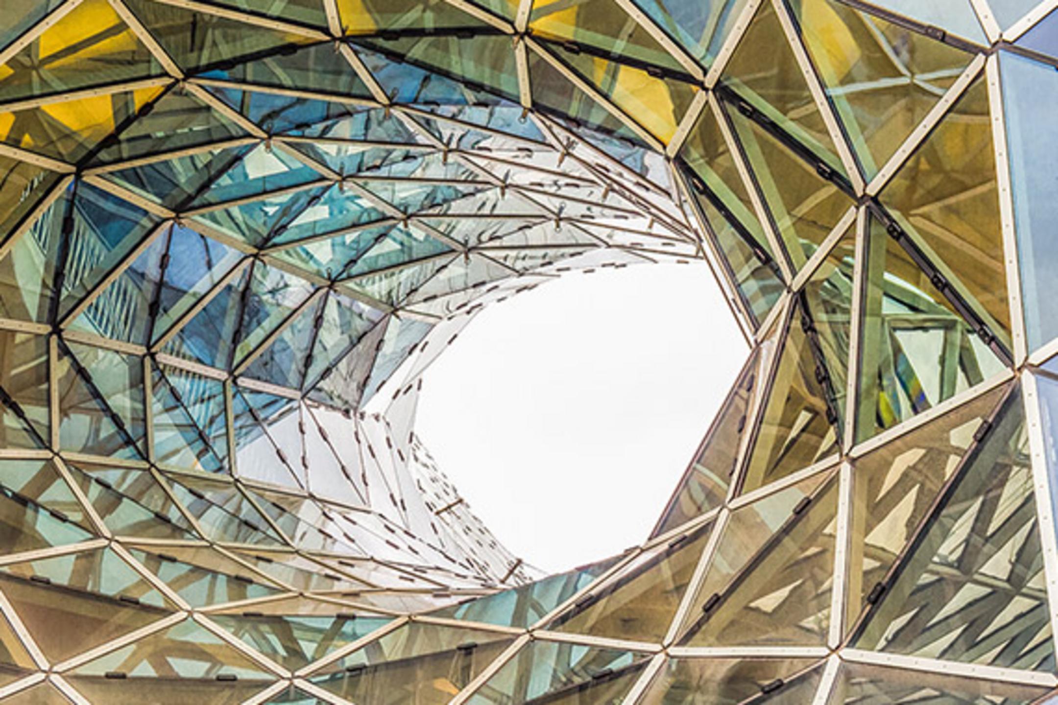 Architektur mit verdrehten Glasdreiecken in Wirbelform, die Licht und Farben reflektieren