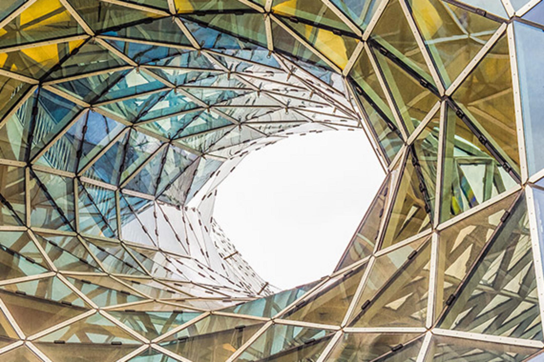 Architektur mit verdrehten Glasdreiecken in Wirbelform, die Licht und Farben reflektieren