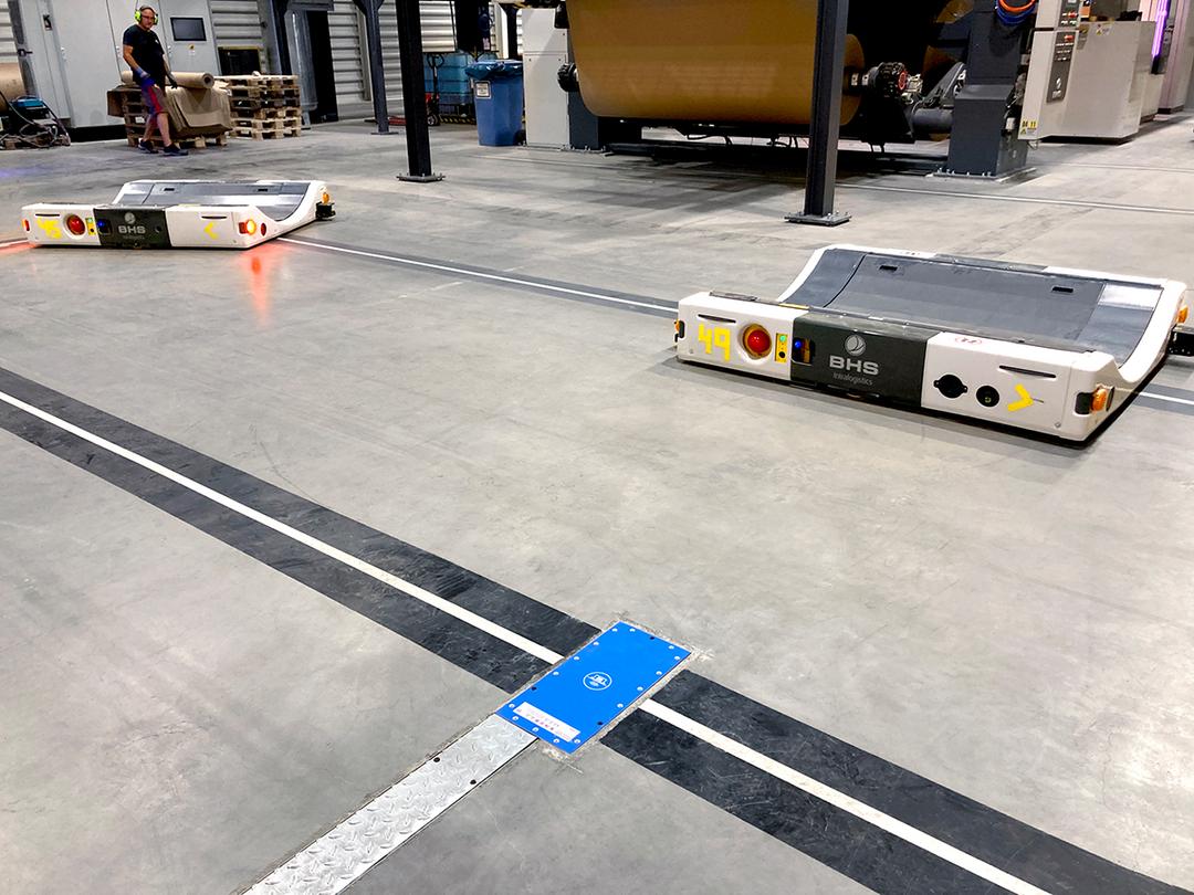 Automatisierte Transportroboter auf markierten Fahrspuren in einer modernen Produktionshalle