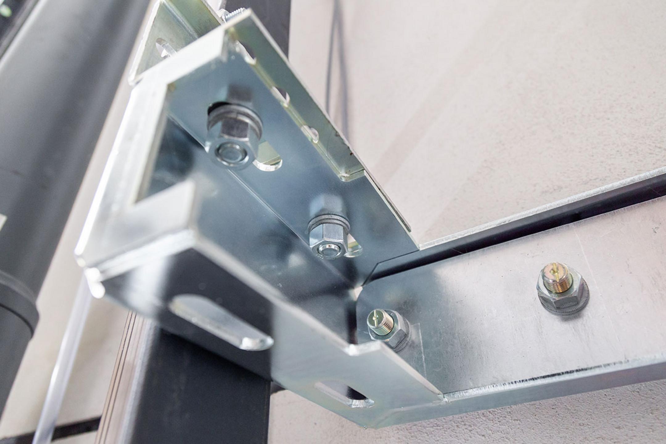 Detailaufnahme einer Aufzugsisolierung mit einer Aufzugsführungsschiene, befestigt mit einer Ankerschiene an der Wand