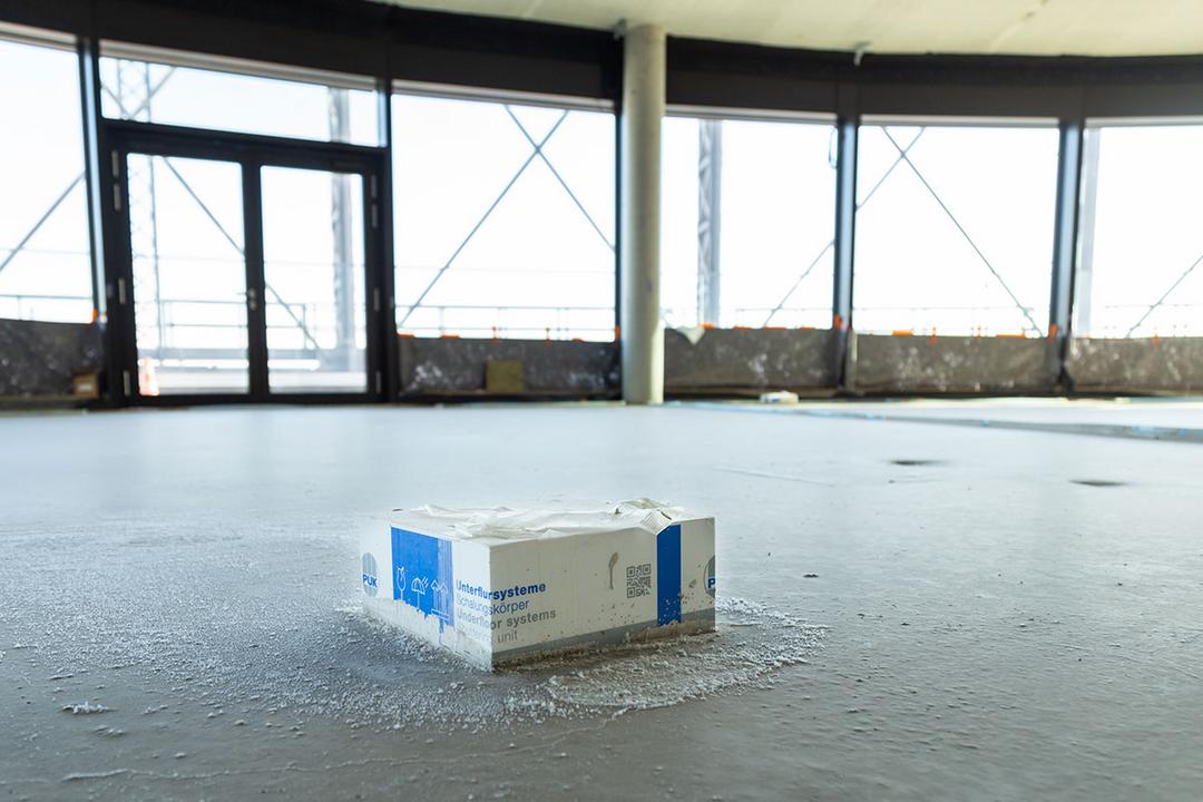 Schalungskörper eines Unterflursystems in frisch gegossenem Boden eines Rohbaus mit großflächiger Fensterfront