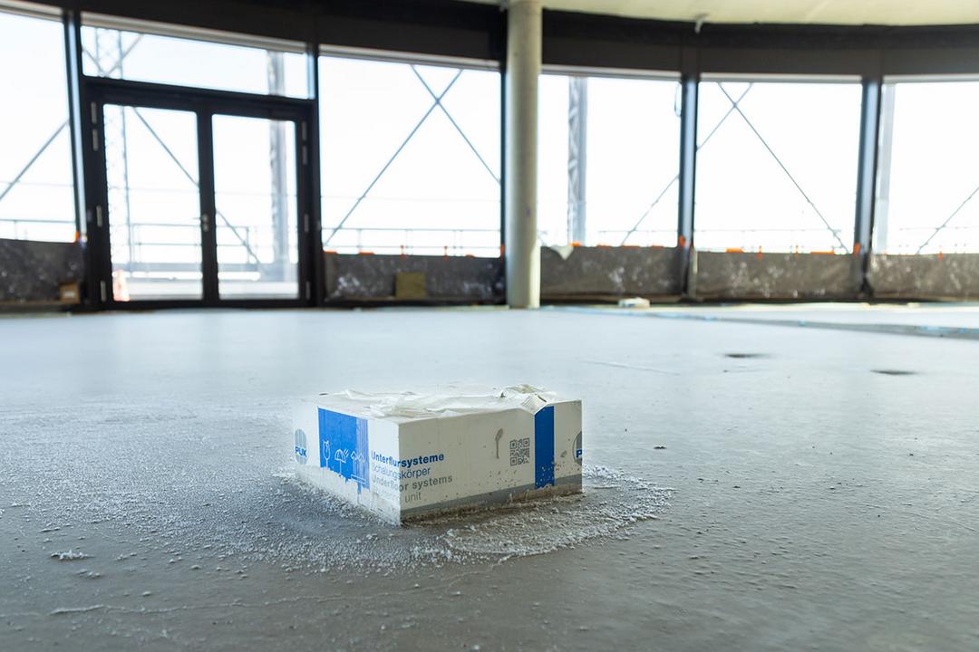 Schalungskörper eines Unterflursystems in frisch gegossenem Boden eines Rohbaus mit großflächiger Fensterfront