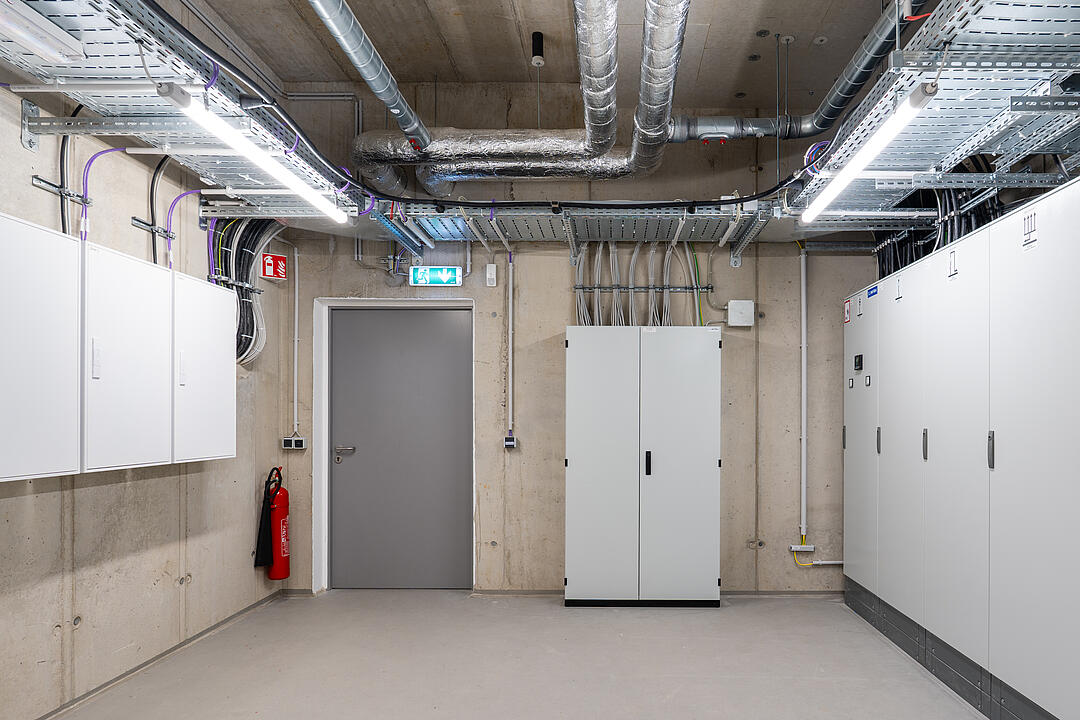 Raum mit mehreren Schränken, Kabel an den Wänden, Kabelrinnen an der Decke.