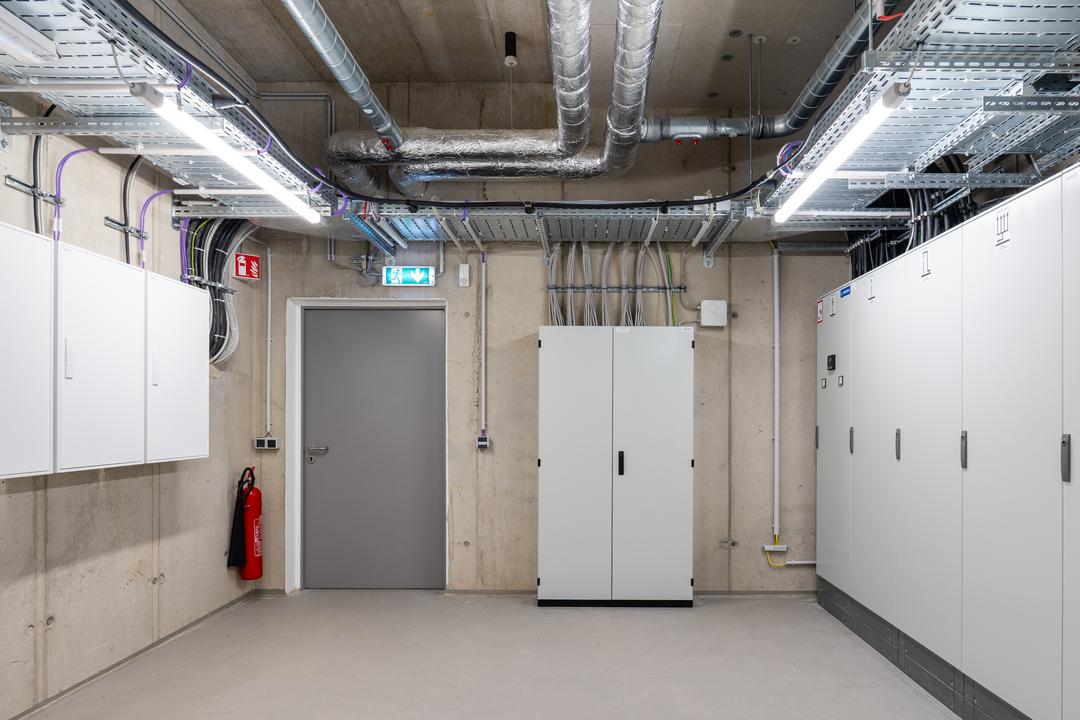 Raum mit mehreren Schränken, Kabel an den Wänden, Kabelrinnen an der Decke.
