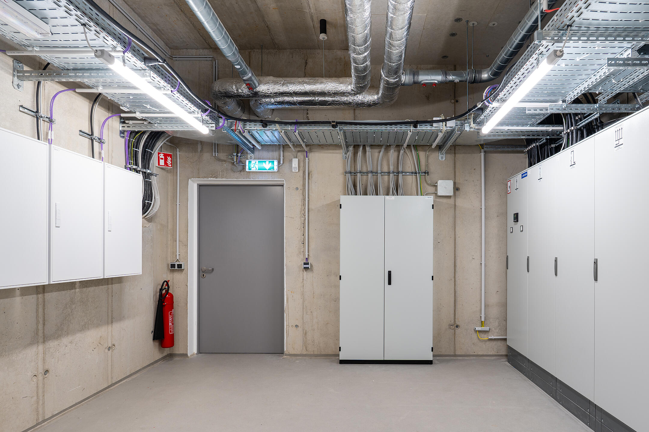 Raum mit mehreren Schränken, Kabel an den Wänden, Kabelrinnen an der Decke.