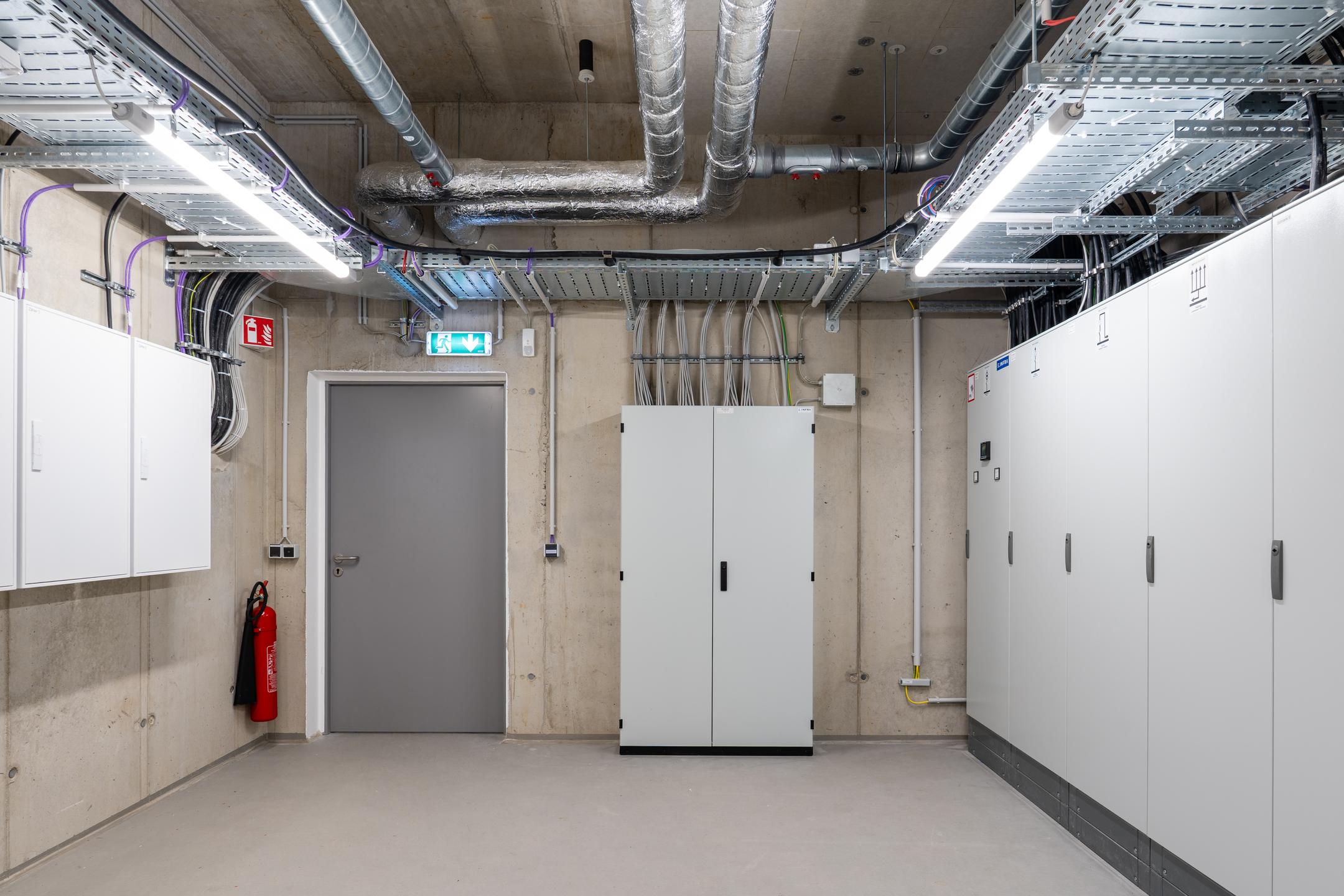Raum mit mehreren Schränken, Kabel an den Wänden, Kabelrinnen an der Decke.