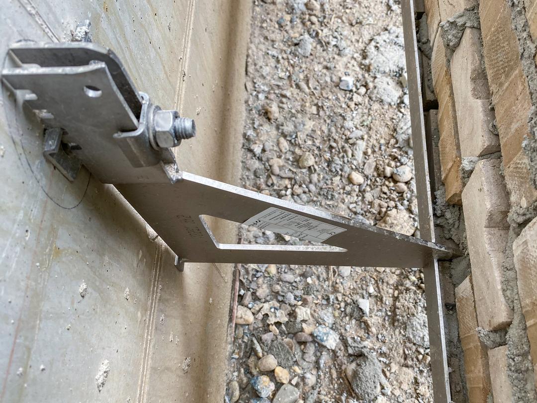 Blick zwischen Vorhangfassade und Betonwand mit Verblenderkonsole