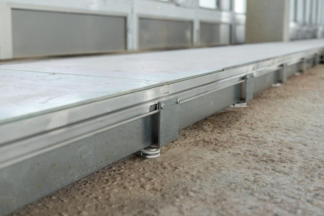 Nahaufnahme eines Bodenkanalsystems mit Nivelierfüßen