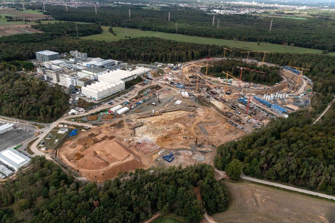 Luftaufnahme mit Blick auf die Baustelle der Anlage mit Kränen, Gebäude und Bäume befinden sich ringsherum