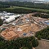 Luftaufnahme mit Blick auf die Baustelle der Anlage mit Kränen, Gebäude und Bäume befinden sich ringsherum