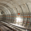 Innenansicht eines modernen U-Bahn-Tunnels mit Schienen, Kabelsystemen und Beleuchtung