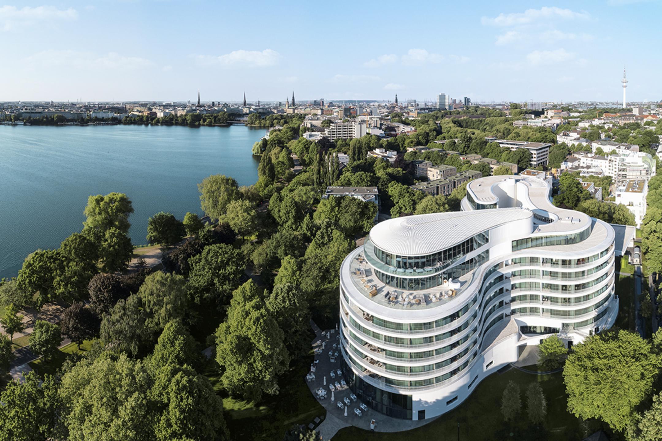 Moderner Gebäudekomplex mit Blick auf die Alster, umgeben von viel Grün im Herzen einer Großstadt