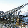 Schneebedeckte Photovoltaik-Freiflächenanlage mit Unterkonstruktion und sichtbarer Verkabelung.