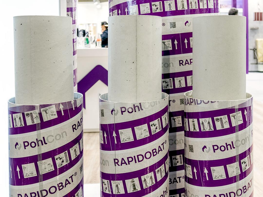 Abgebildet sind nebeneinander drei RAPIDOBAT® Schalrohre in den Ausführungen Glatt-light, Glatt und Cretcon HD, in der charakteristischen weiß-lila Verpackung.