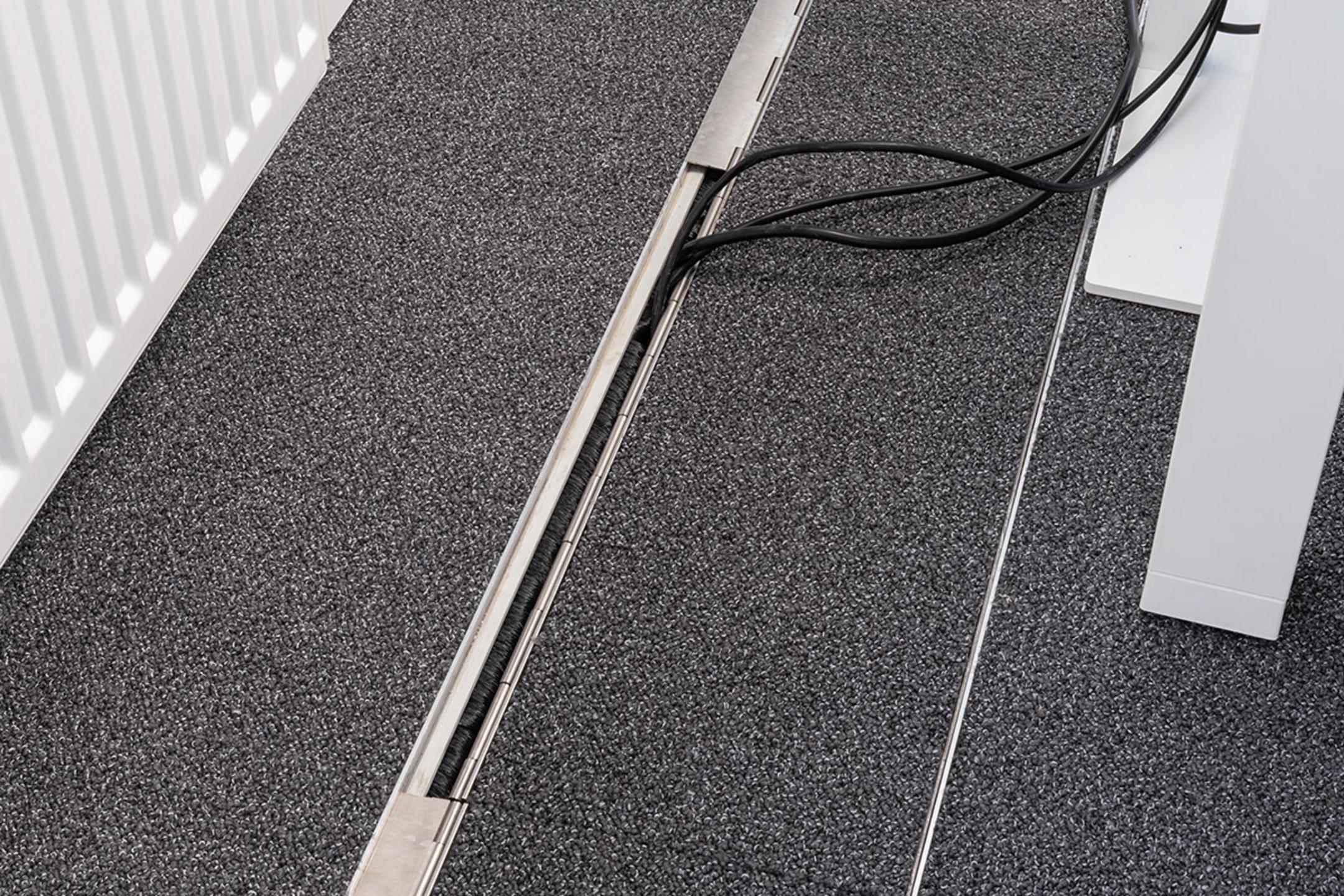 Das in den Boden eingelassene Kanalsystem für Kabel, geschlossen, in einem Büro.