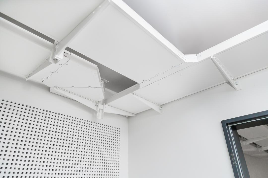 Weiße Decke mit abgehängter ungelochter Kabelrinne in Weiß und perforierter Wandverkleidung