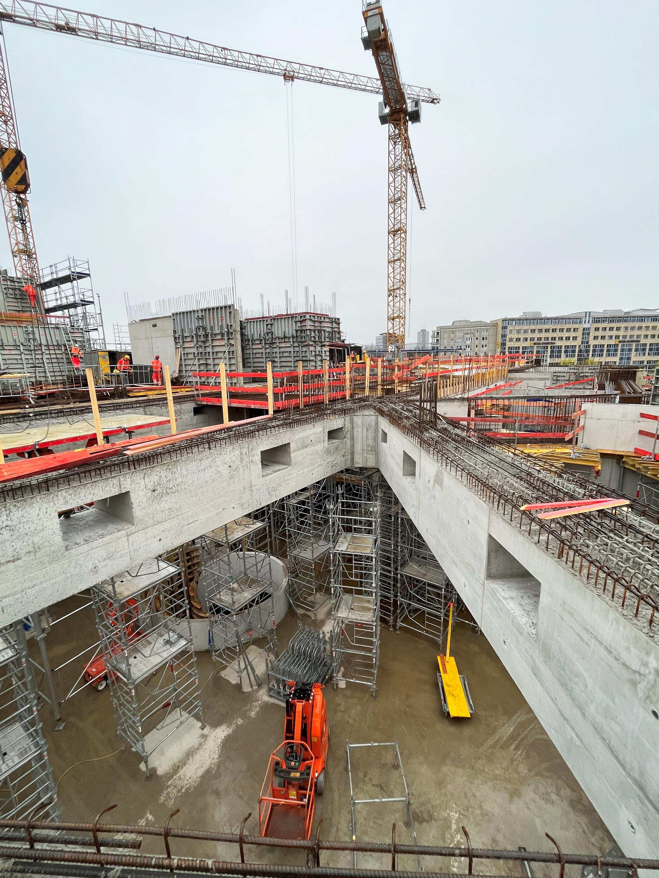 Blick auf eine Baustelle mit Gerüsten und Baukränen.