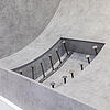 Ausstellungsmodell eines Tunnelbauteils mit eingebauten Ankern und Verbindungselementen in einer Betonvertiefung.
