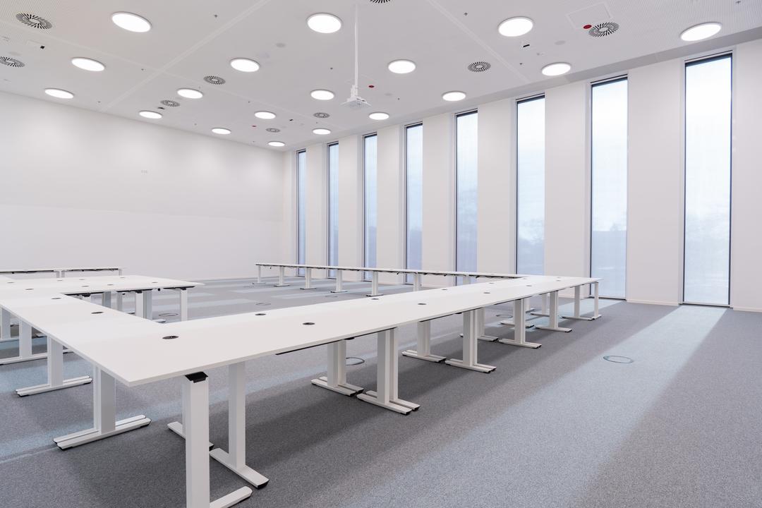 Büroraum mit weißen Tischen und Fensterfront