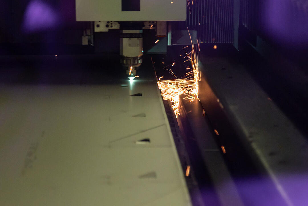 Laser schneidet Metallblech mit sichtbarem Funkenflug