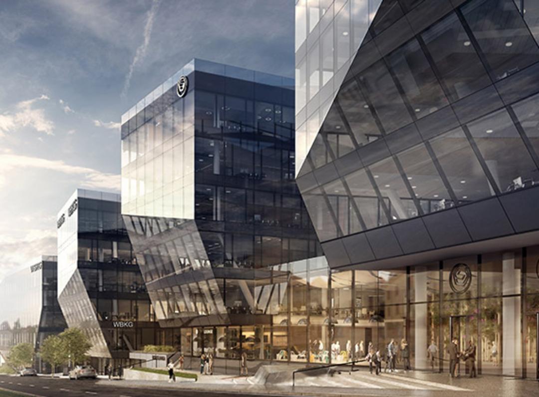 Eine futuristisch anmutende Gruppe von komplett verglasten Gebäuden vor einem aufgewühlten Himmel.