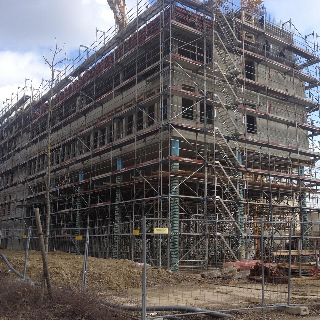 Blick auf das Bürogebäude, als es noch gebaut wird – umgeben von Gerüsten.