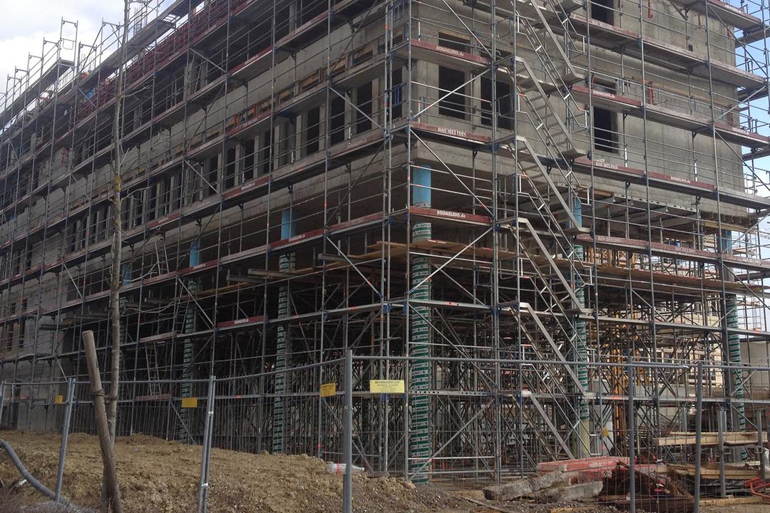 Blick auf das Bürogebäude, als es noch gebaut wird – umgeben von Gerüsten.