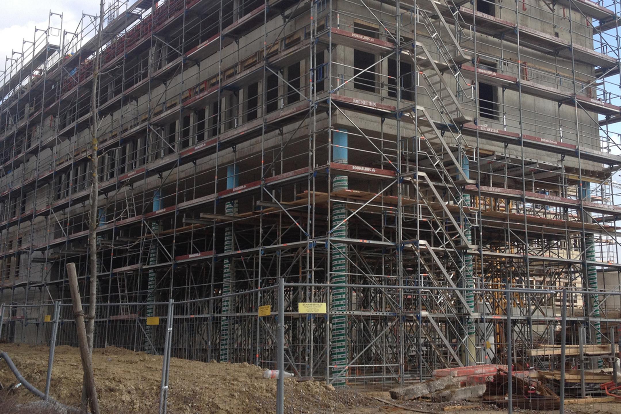 Blick auf das Bürogebäude, als es noch gebaut wird – umgeben von Gerüsten.