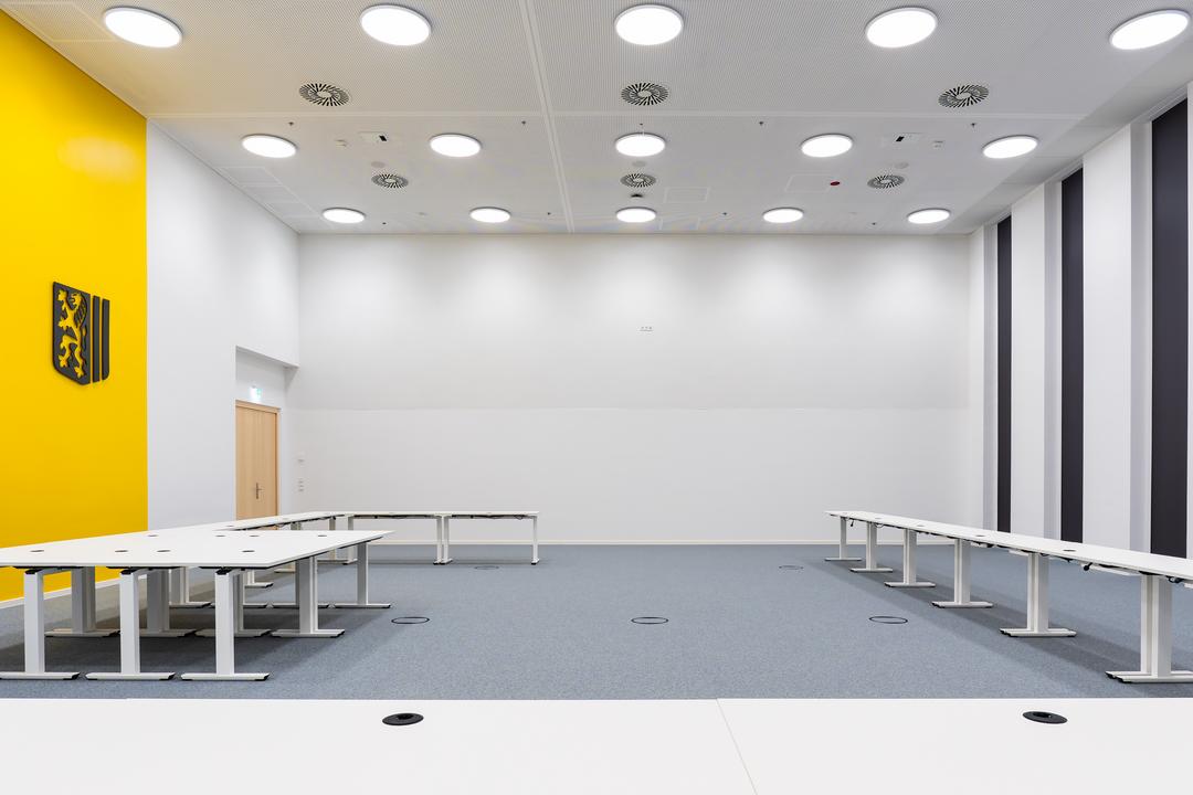 Großer, heller Raum, mehrere Tische in der Mitte des Raumes, Klappdeckeleinheiten im Boden.