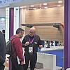 Messestand mit Ausstellungsstück Kabeltragsystem, Messepersonal und Besuchern