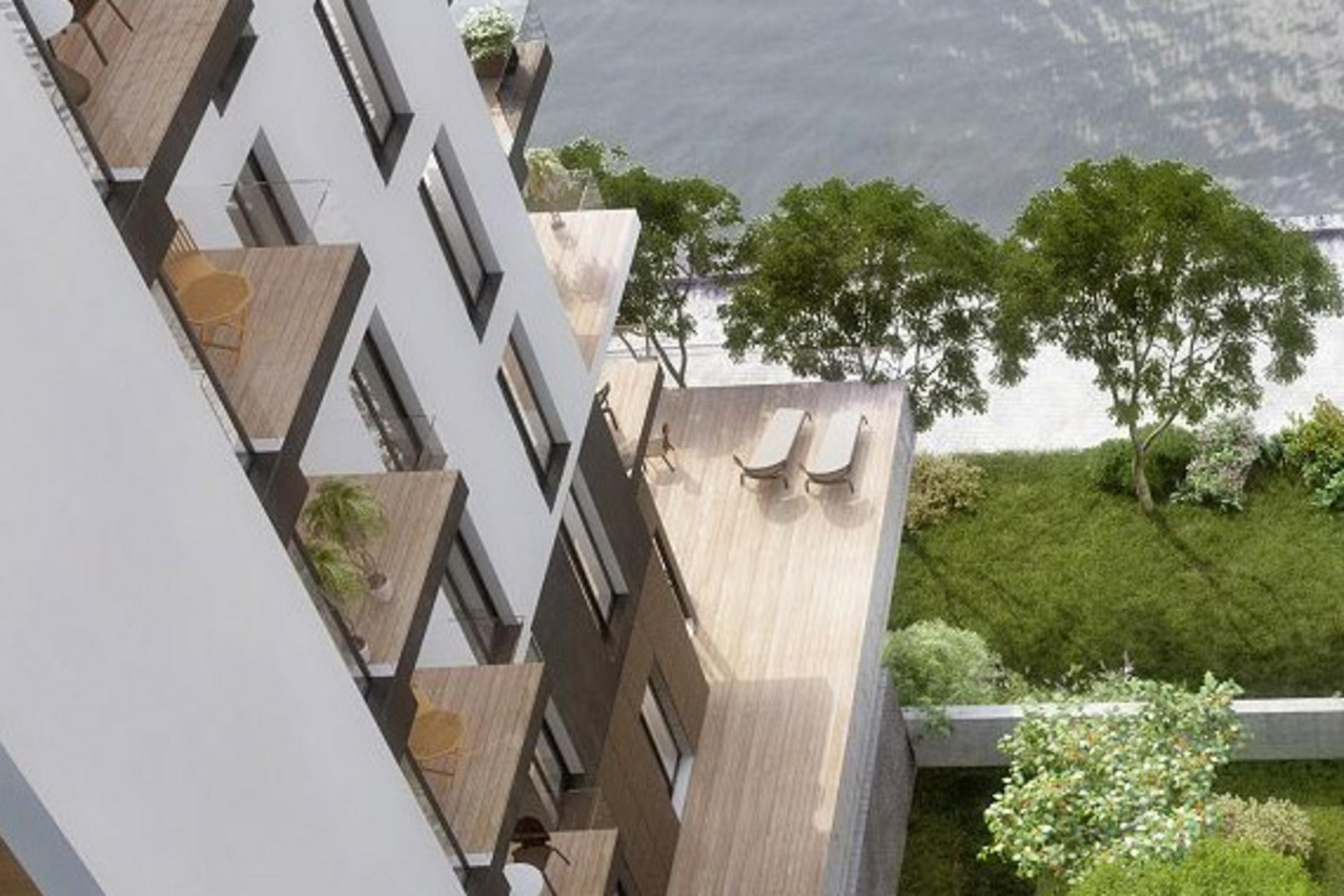 3D-Visualisierung einer Luftaufnahme eines modernen Wohnhauses mit Balkonen, großer Terrasse und Blick auf Wasser mit Uferbegrünung